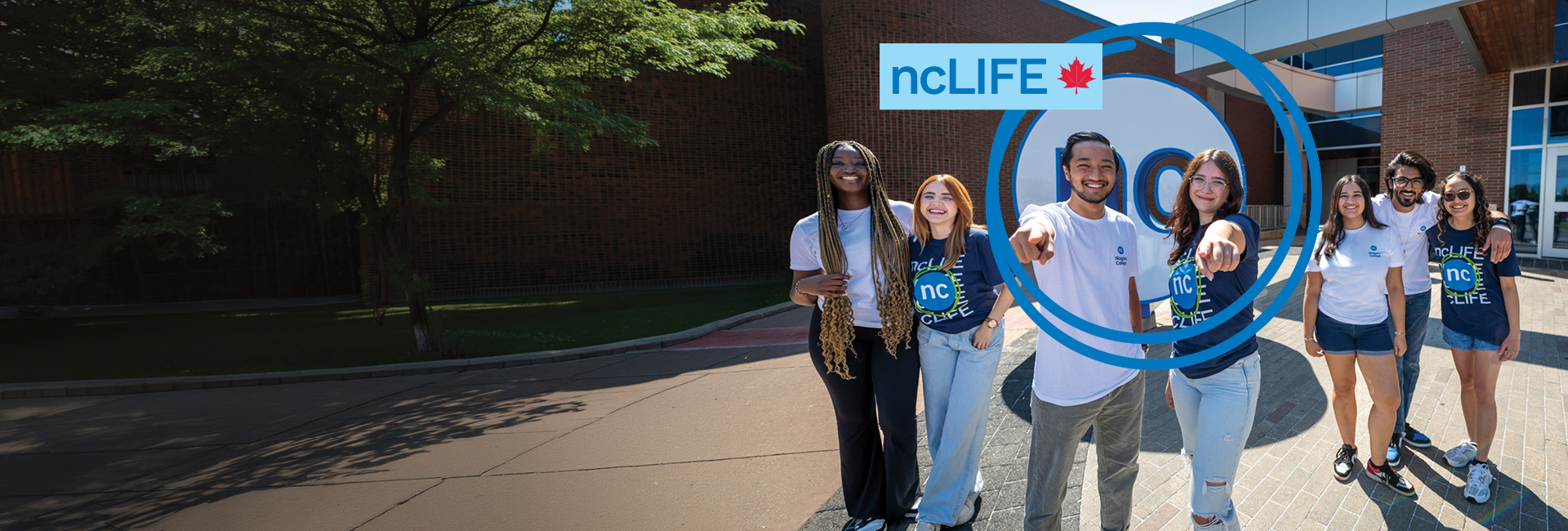 Six smiling students stand together outside a building, all wearing ncLIFE and Niagara College T-shirts.