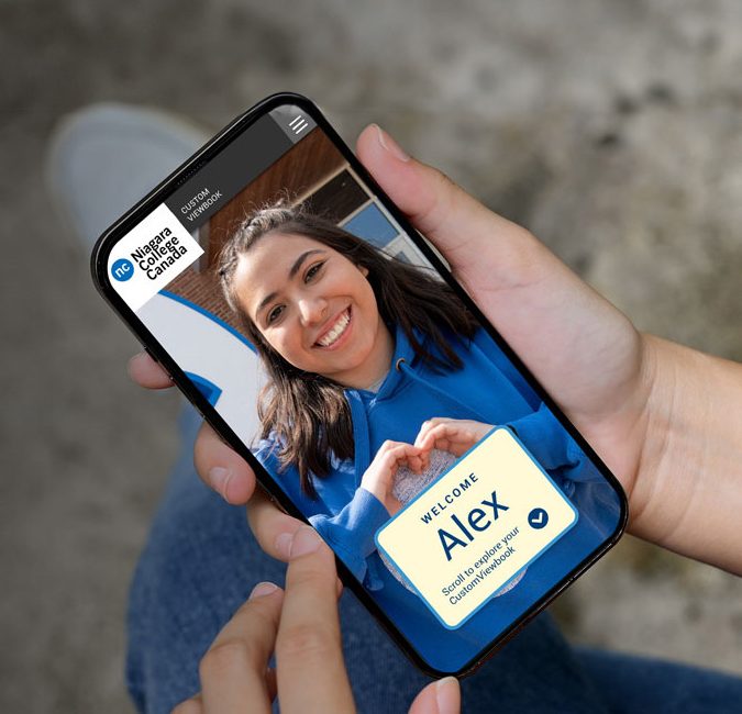 Person holding a mobile phone displaying a video call with someone named Alex, who is smiling and wearing a blue shirt.