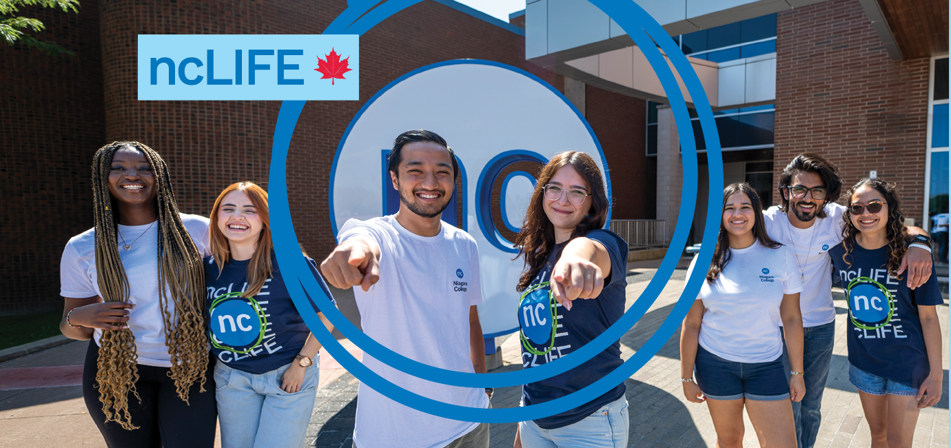Six smiling students stand together outside a building, all wearing ncLIFE and Niagara College T-shirts.